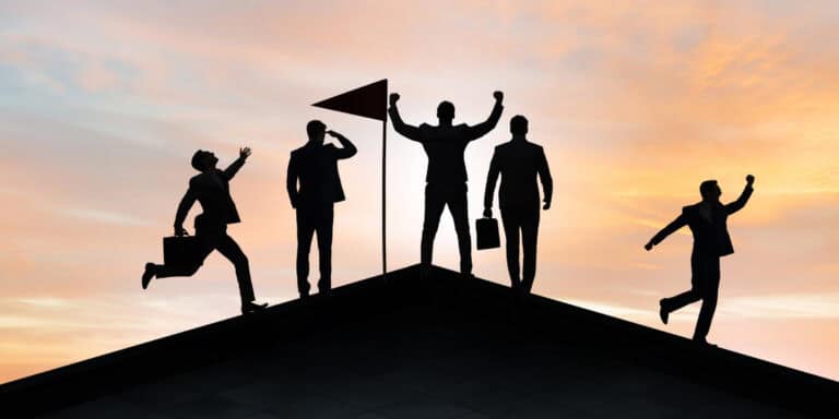Silhouettes of business people on top of a roof.