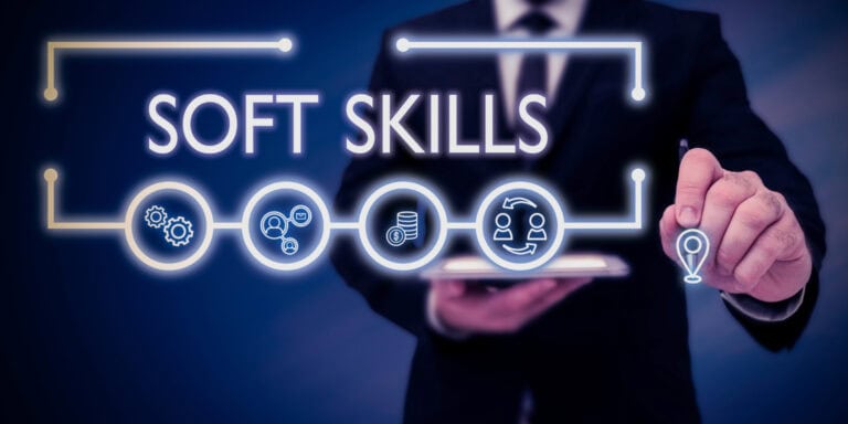 A man in a suit is holding up a sign that says soft skills.
