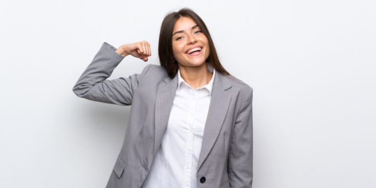 A young business woman flexing her arm.