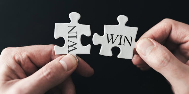 Two hands holding a puzzle piece with the words win and lose.
