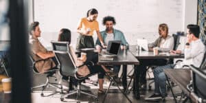 A group of people sitting around a table in an office.