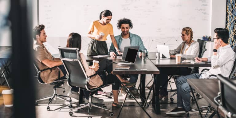 A group of people sitting around a table in an office.