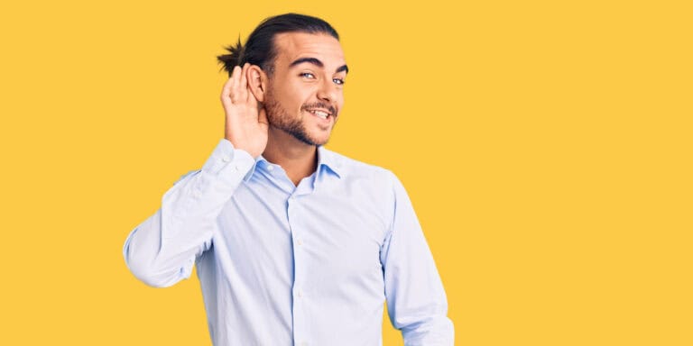 man listening yellow background
