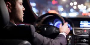 A man driving a car at night.