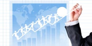 A businessman drawing a graph with people on it.