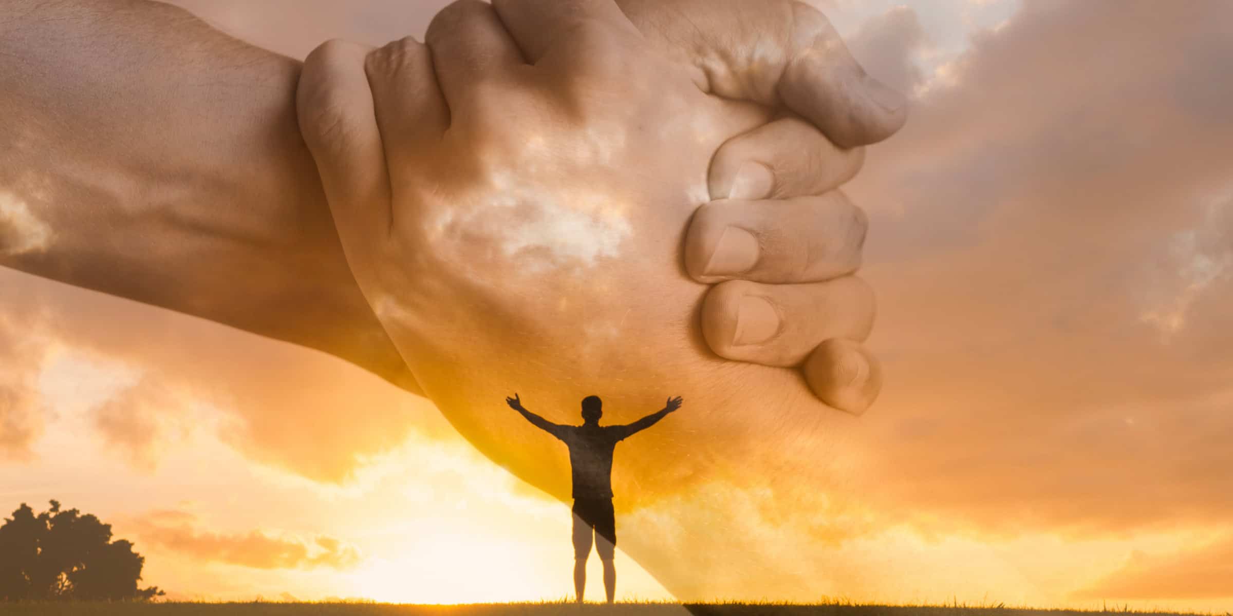 A person holding a person's hand at sunset.