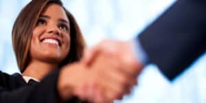 A woman is shaking hands with another woman.