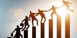 Silhouettes of business people climbing up a ladder.