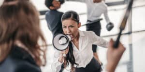 A woman is shouting at another woman with a megaphone.
