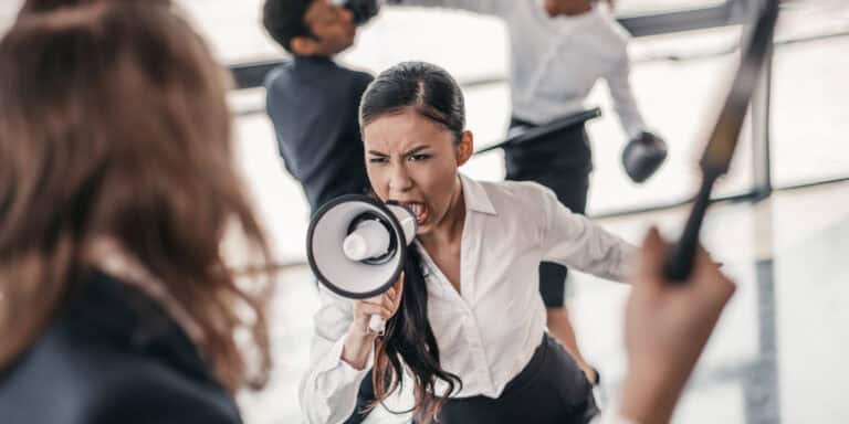 A woman is shouting at another woman with a megaphone.