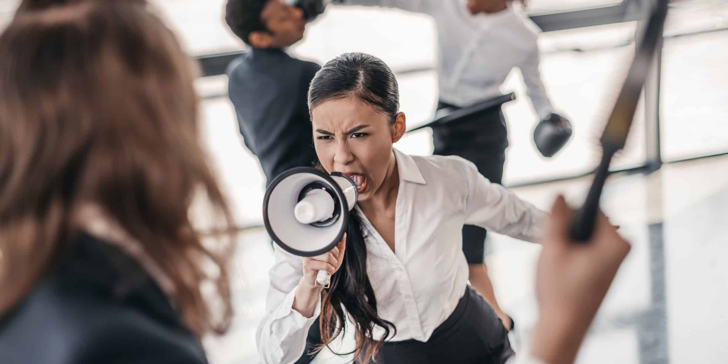 A woman is shouting at another woman with a megaphone.