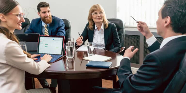 A group of business people sitting around a conference table.