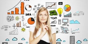A woman is looking at a wall with business icons drawn on it.