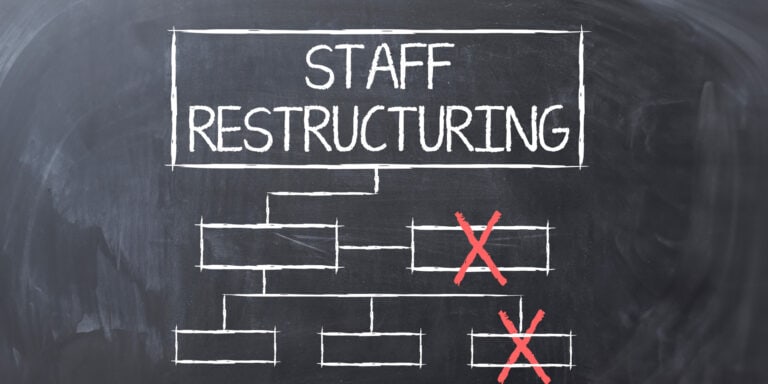 A blackboard with the word staff restructuring written on it.