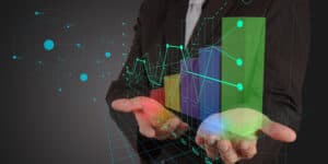 A businessman in a suit holding a graph on his hand.