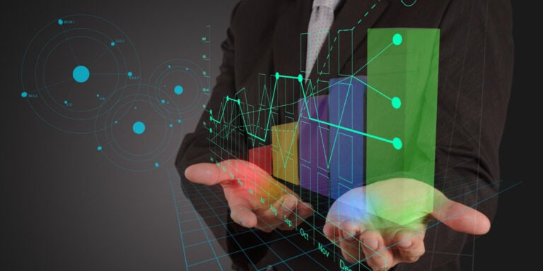 A businessman in a suit holding a graph on his hand.