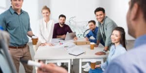 A group of people sitting around a table in an office.