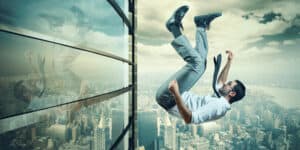 A man falling out of a window of a building.