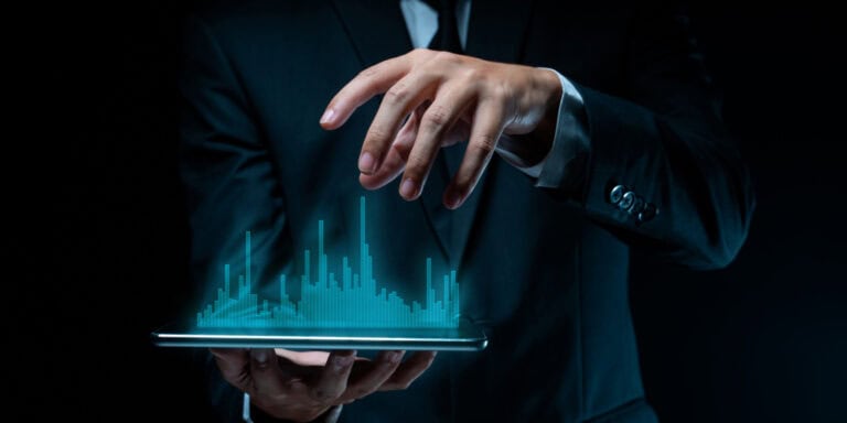 A businessman is holding a tablet with a city on it.