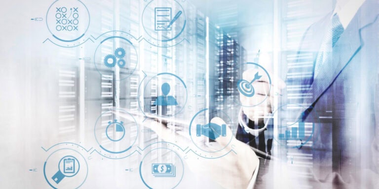 A man in a suit is holding a tablet in front of a server.