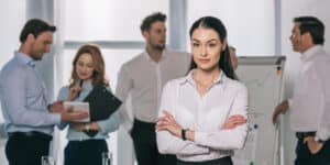 A business woman standing in front of a group of people.