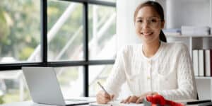 A woman sitting at a desk with a laptop.