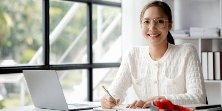 A woman sitting at a desk with a laptop.