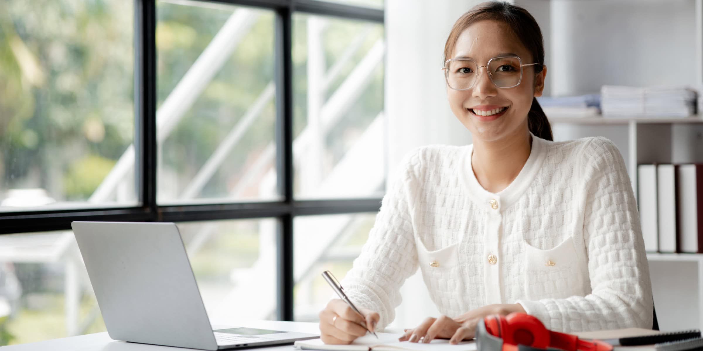 A woman sitting at a desk with a laptop.