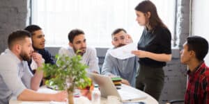 A group of people sitting around a table in an office.