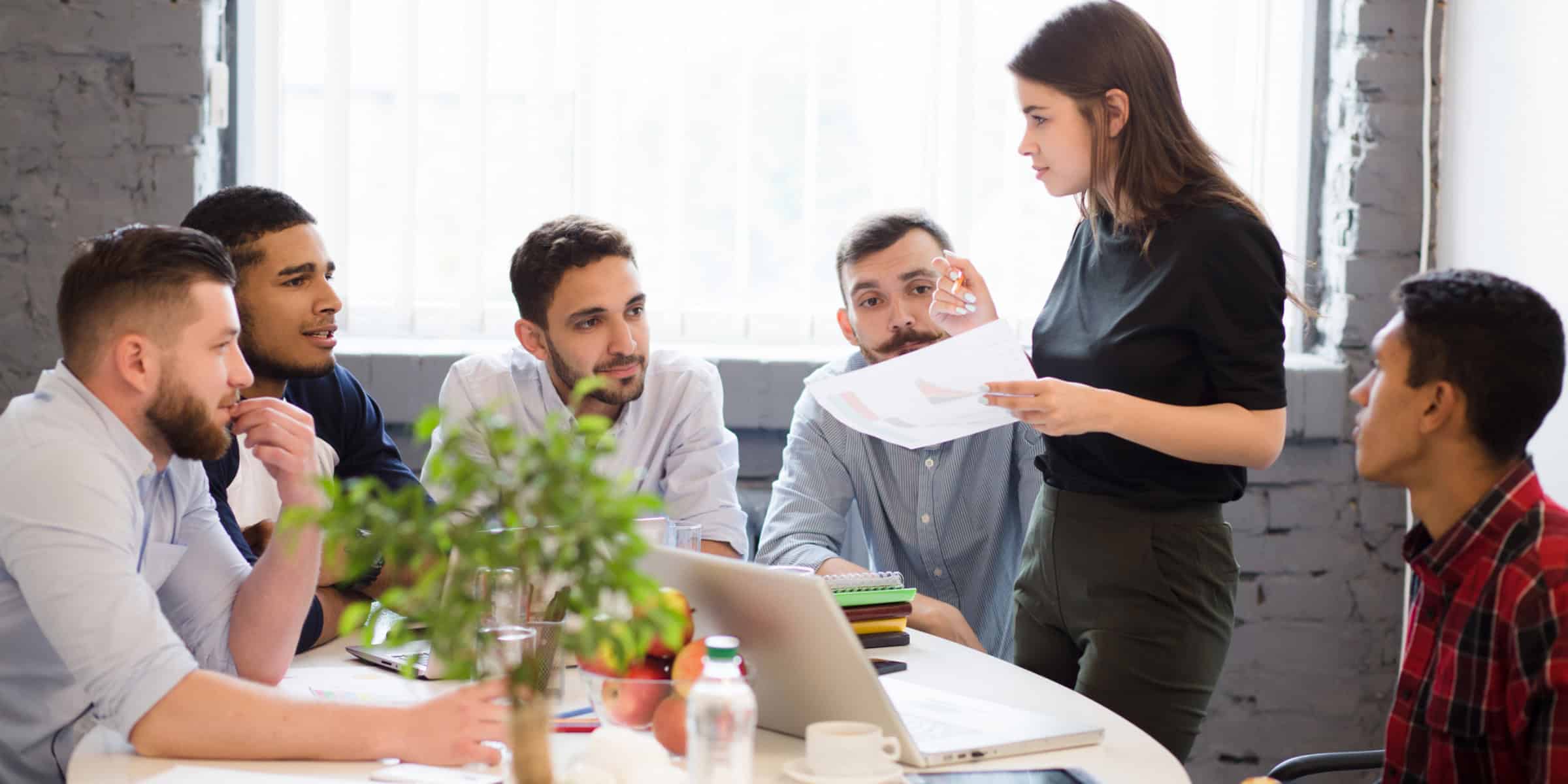 A group of people sitting around a table in an office.