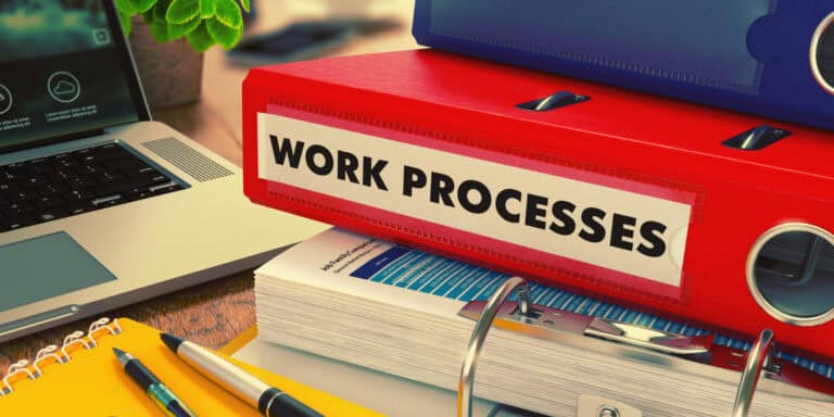 A stack of binders with the word work processes on them.