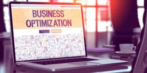 A laptop with the word business optimization on it.