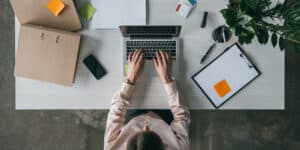 A woman working on her laptop at a desk.