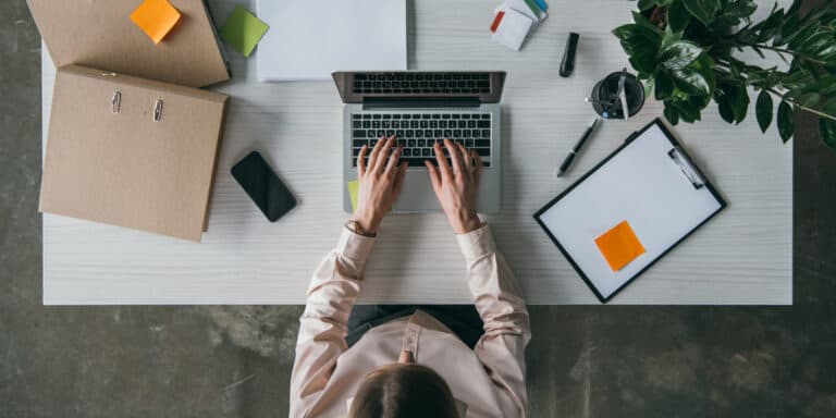 A woman working on her laptop at a desk.