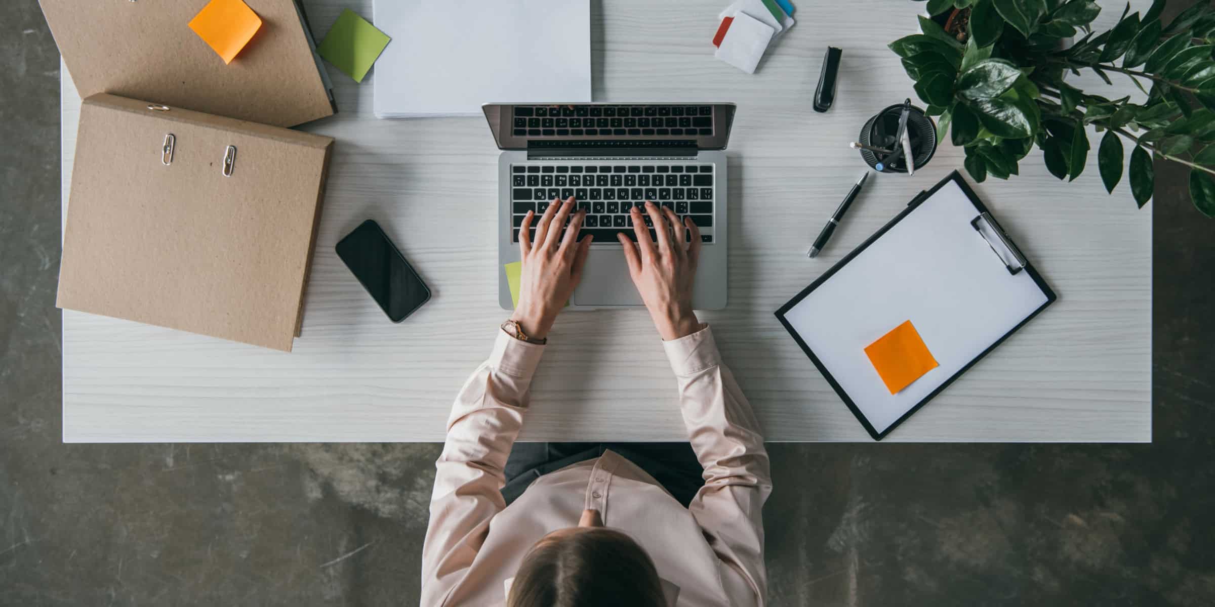 A woman working on her laptop at a desk.