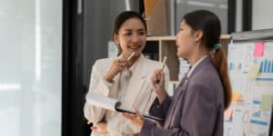 Two business women talking in an office.