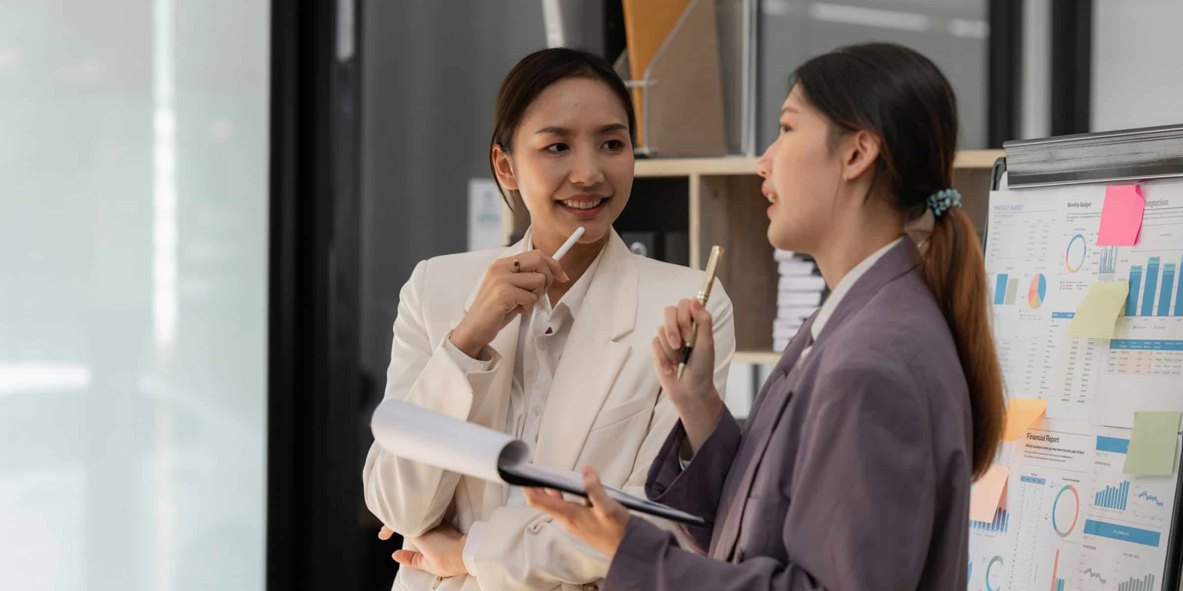 Two business women talking in an office.