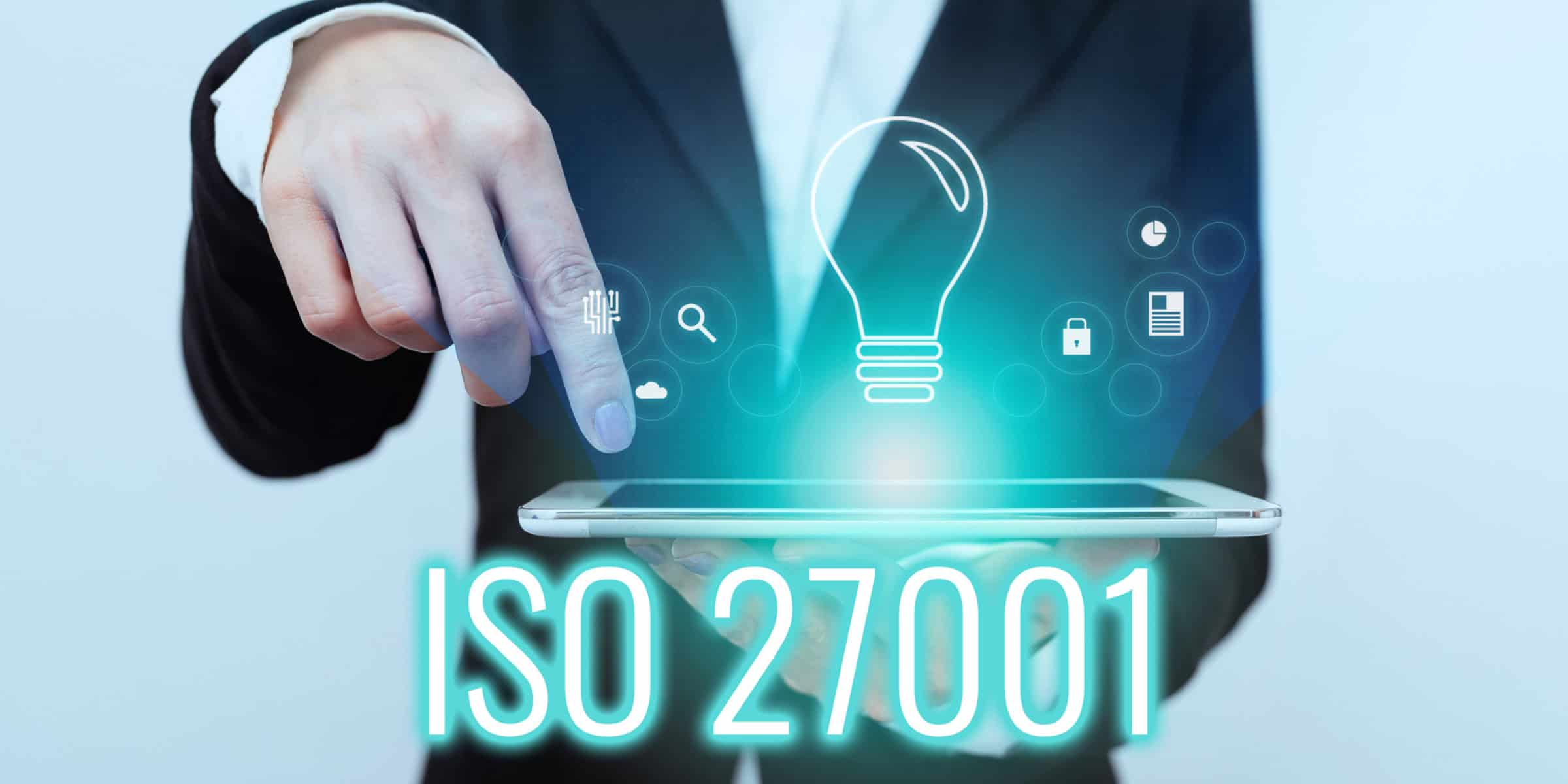 A businessman is holding a tablet with the word iso 27001 on it.