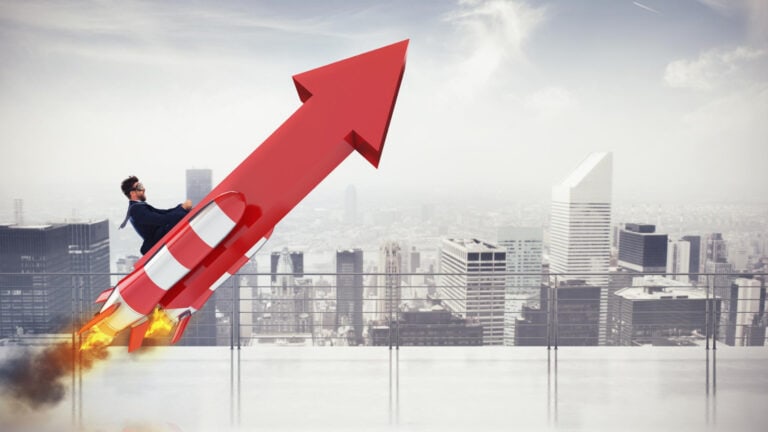 A businessman is flying up a red arrow with a city in the background.
