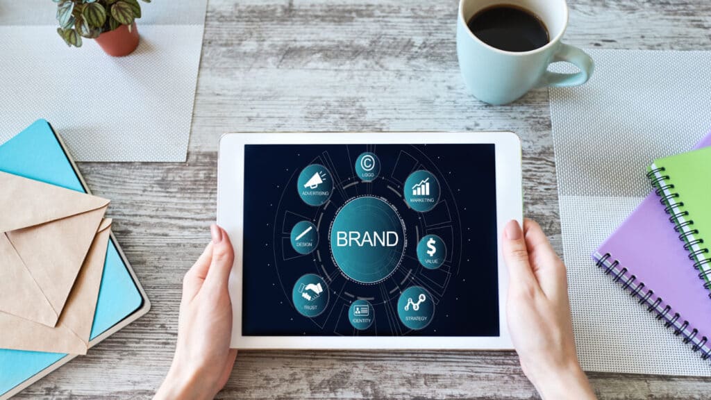 A woman holding an ipad with the word brand on it.