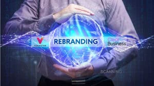 A man is holding up a rebranding logo.