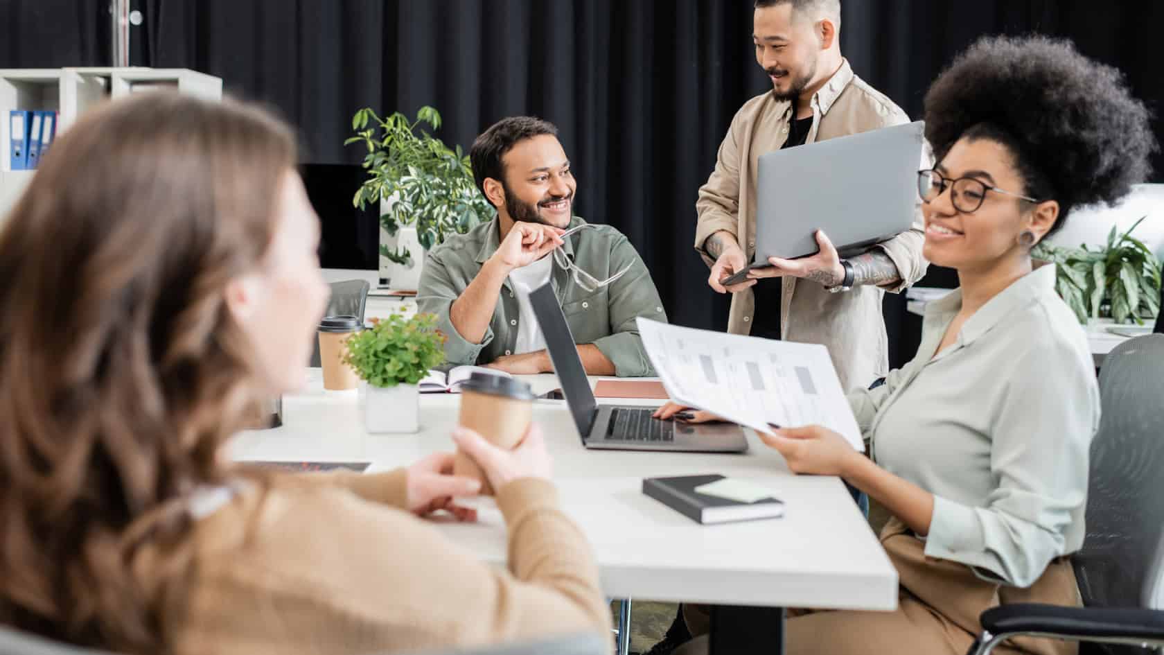 A group of people sitting around a table in an office.