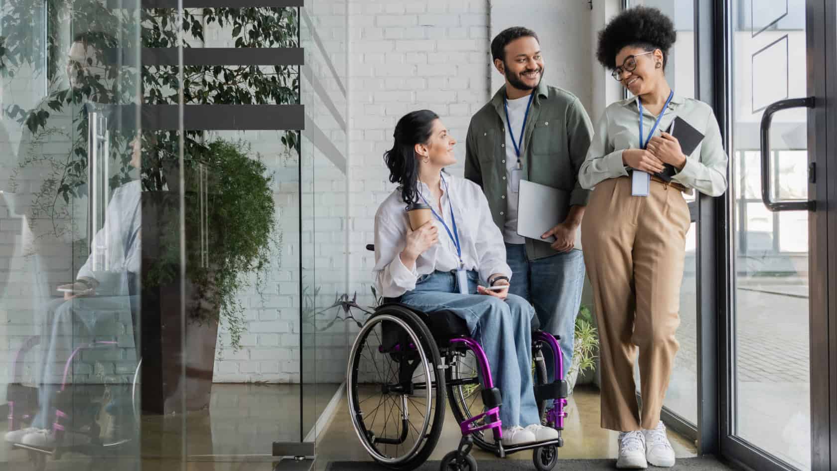A group of people in a wheelchair standing in front of a glass door.