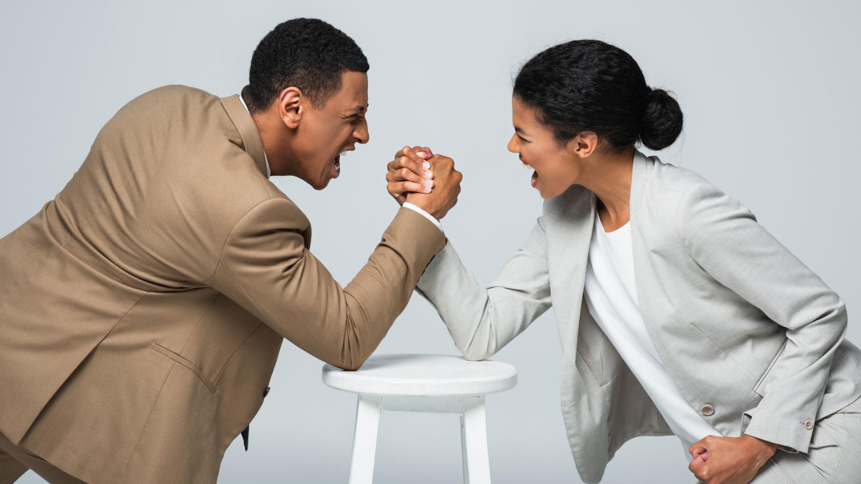 Two black business people fighting with each other on a white background.