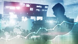 A man is standing in front of a business graph.