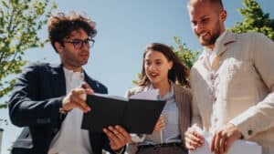 Three business people looking at a document.