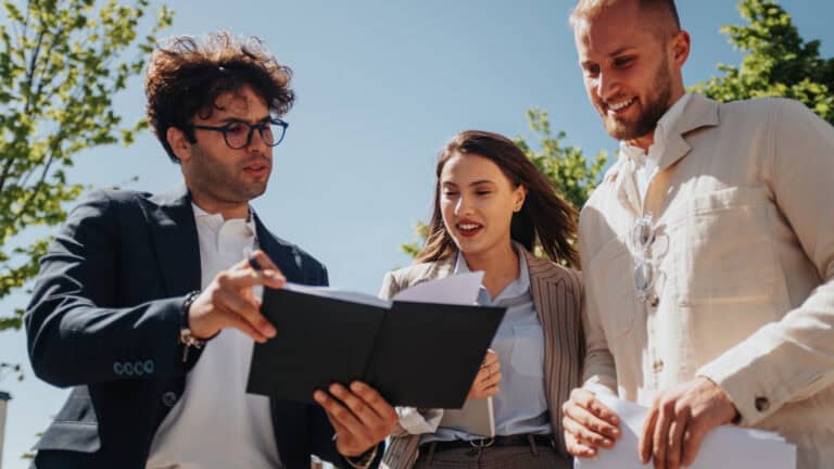 Three business people looking at a document.